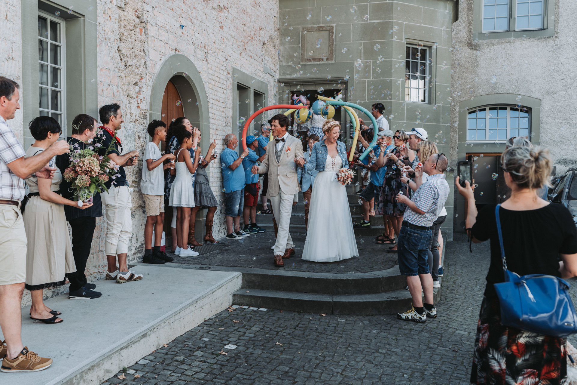 Hochzeitsfoto von spalierstehenden Leuten die das Brautpaar in Empfang nehmen